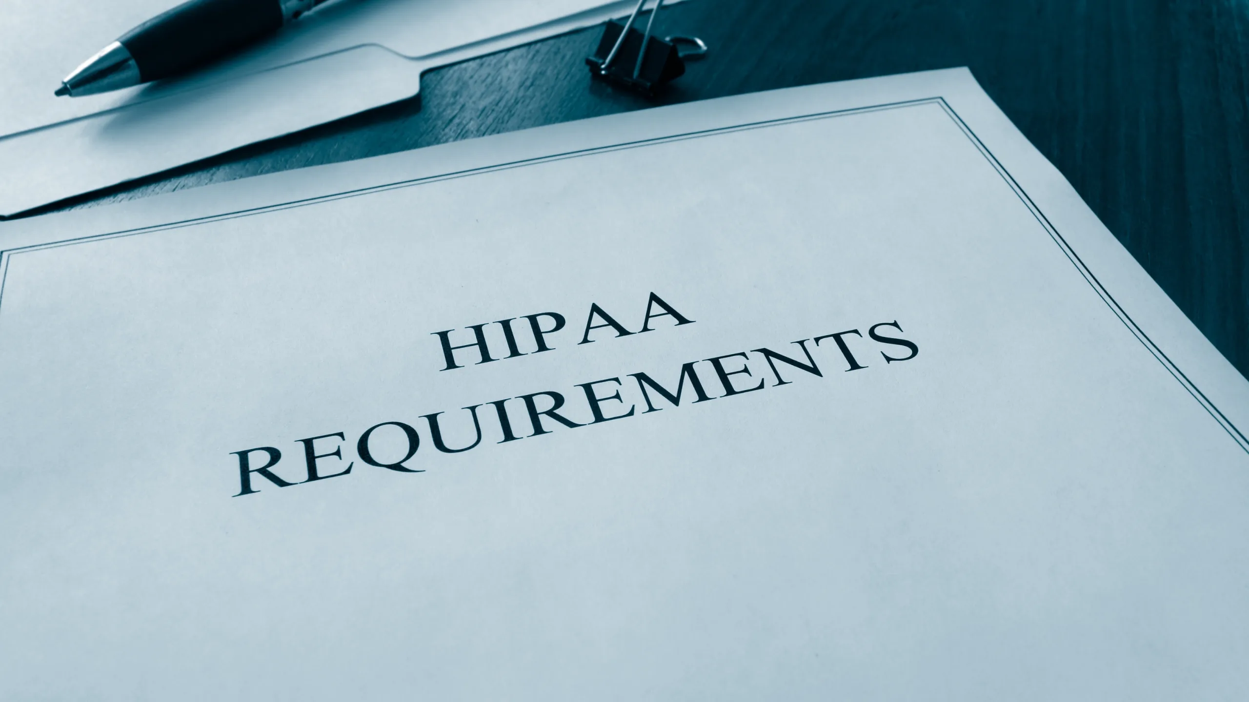 A clipboard listing HIPAA compliance requirements on a clinician's desk